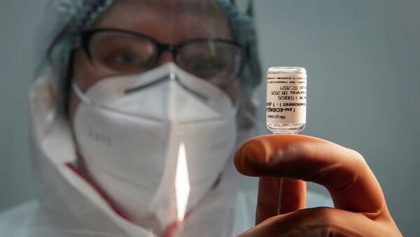 Медик набирает вакцину Спутник V в шприц для инъекции - Sputnik Казахстан