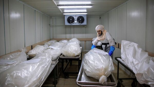 Работник морга упаковывает тела погибших от коронавируса  - Sputnik Казахстан