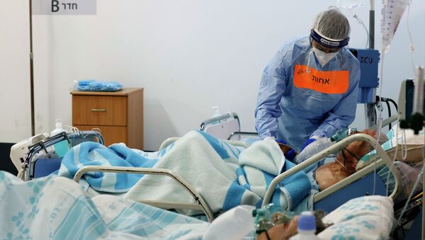 Врач осматривает пациента в реанимации в больнице с коронавирусом - Sputnik Қазақстан