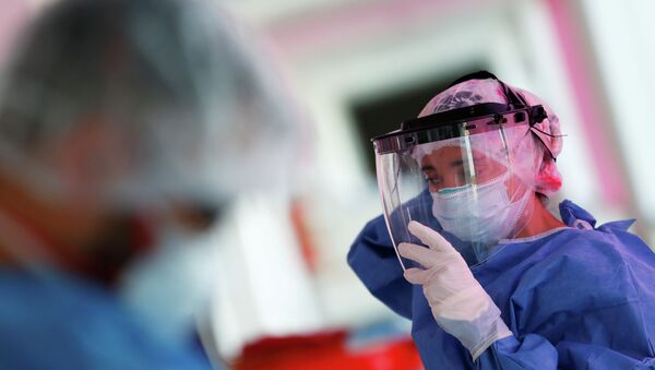 Врач надевает защитный экран в больнице с коронавирусом  - Sputnik Казахстан