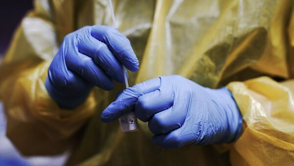 Медик в защитном костюме держит в руках пробирку с ПЦР-тестом на коронавирус  - Sputnik Қазақстан