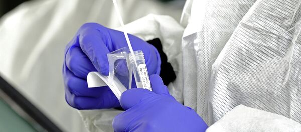 Медик в защитном костюме держит в руках пробирку с ПЦР-тестом на коронавирус Медик в защитном костюме держит в руках пробирку с ПЦР-тестом на коронавирус - Sputnik Казахстан