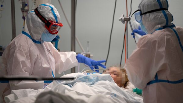 Врачи с пациентом в палате интенсивной терапии в больнице с коронавирусом  - Sputnik Казахстан