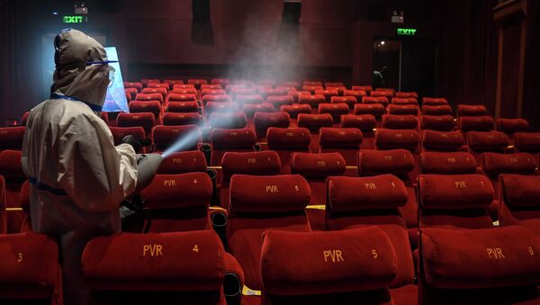 Сотрудник кинотеатра проводит дезинфекцию в зрительном зале  - Sputnik Қазақстан
