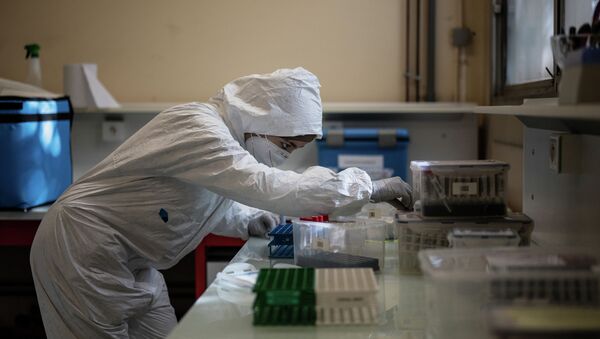 Сотрудник лаборатории маркирует коробки пробирок с анализами на коронавирус - Sputnik Казахстан