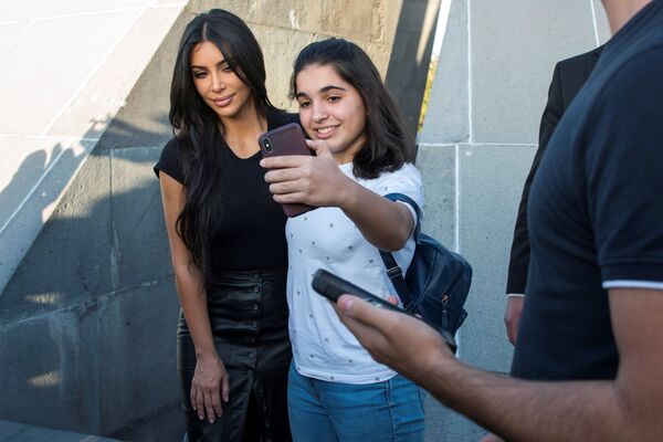 Звезда американского реалити-шоу Ким Кардашьян позирует для селфи с девушкой во время посещения Мемориала геноцида армян Цицернакаберд в Ереване 8 октября 2019 года - Sputnik Казахстан