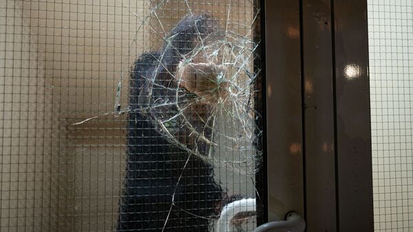 Мужчина разбивает стекло подъезда, иллюстративное фото  - Sputnik Қазақстан