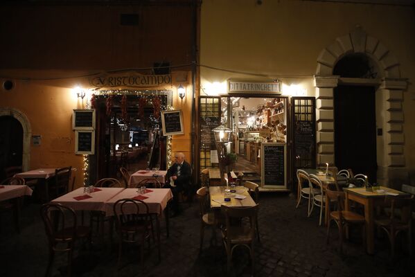 Мужчина на террасе пустого ресторана в Риме, Италия - Sputnik Қазақстан
