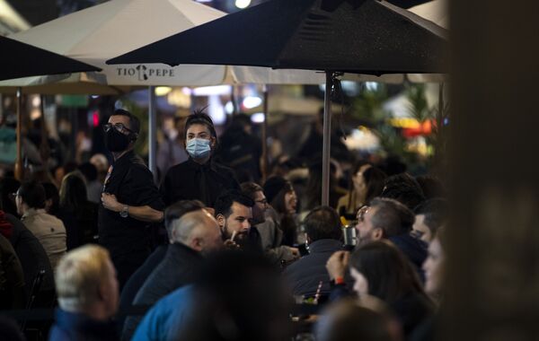 Официанты в медицинских масках на пешеходной части Олд-Комптон-стрит в Лондоне, Великобритания - Sputnik Қазақстан