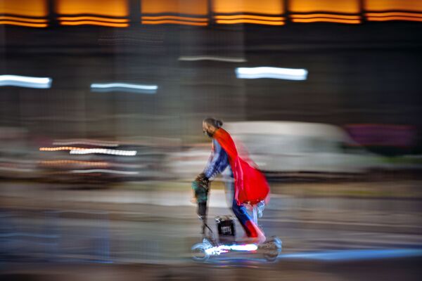 Мужчина в костюме супермена едет на скутере по улице Бухареста, Румыния - Sputnik Казахстан