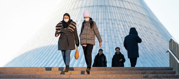 Девушки в масках спускаются по ступенькам Девушки в масках спускаются по ступенькам - Sputnik Казахстан
