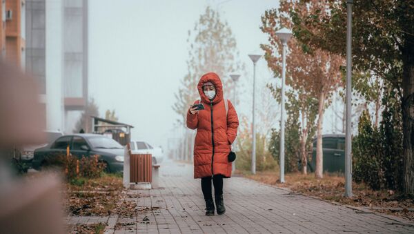 Женщина в маске идет по туманной улице - Sputnik Казахстан