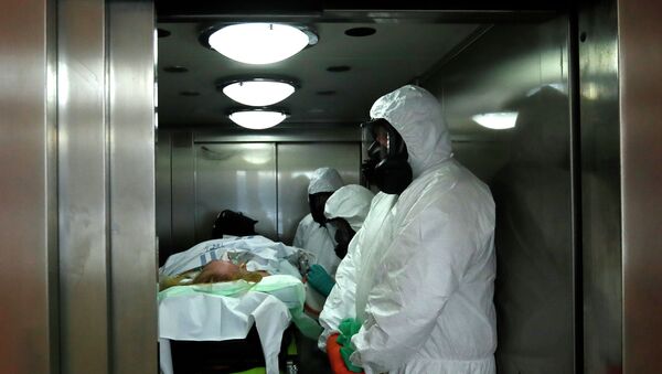 Медики в защитных костюмах поднимаются на лифте в больнице с коронавирусом  - Sputnik Казахстан