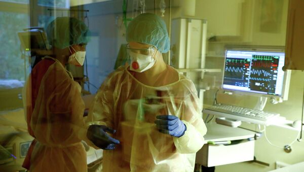 Врачи у кровати пациента в реанимации в больнице с коронавирусом - Sputnik Казахстан