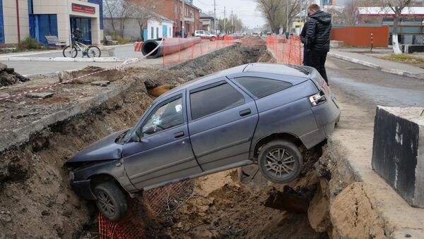 Автомобиль упал в ров, вырытый коммунальными службами в Петропавловске - Sputnik Казахстан