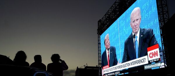 Люди смотрят прямую трансляцию дебатов Дональда Трампа и Джо Байдена на уличном экране Люди смотрят прямую трансляцию дебатов Дональда Трампа и Джо Байдена на уличном экране - Sputnik Казахстан