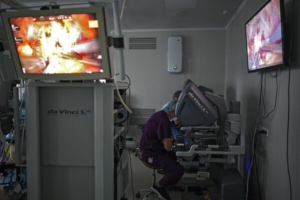 Хирурги следят за происходящей операцией через монитор в операционной городской клинической больницы №50 в Москве - Sputnik Казахстан