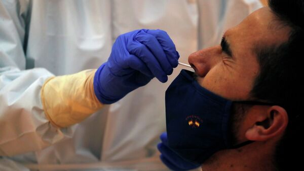 Врач берет у мужчины ПЦР-пробу для анализа на коронавирус   - Sputnik Казахстан