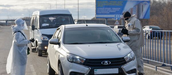 Врач и полицейский общаются с водителем автомобиля у блокпоста Врач и полицейский общаются с водителем автомобиля у блокпоста - Sputnik Казахстан