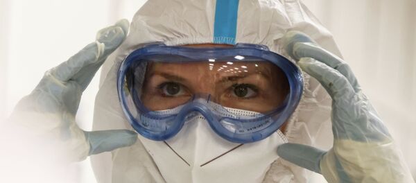 Медик поправляет защитный костюм в больнице с коронавирусом - Sputnik Казахстан