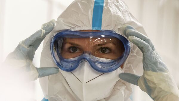Медик поправляет защитный костюм в больнице с коронавирусом - Sputnik Казахстан