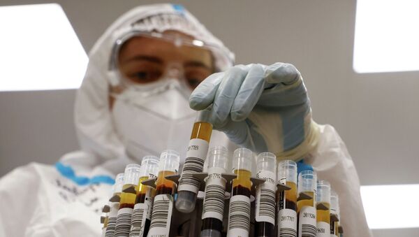 Медик размещает пробирки с пробами на коронавирус на центрифуге в лаборатории больницы с коронавирусом  - Sputnik Казахстан