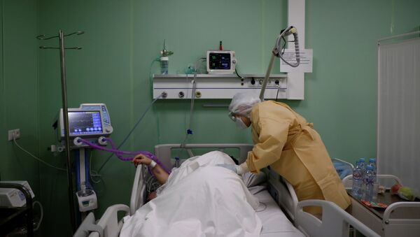 Медсестра у постели пациентки в больнице с коронавирусом  - Sputnik Казахстан