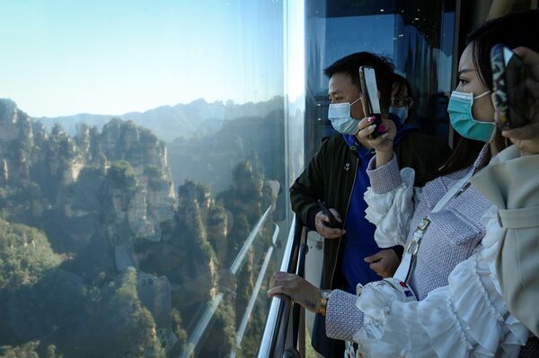 Туристы фотографирую окрестности во время поездки в лифте Байлун в национальном парке Чжанцзяцзе в провинции Хунань, Китай - Sputnik Казахстан
