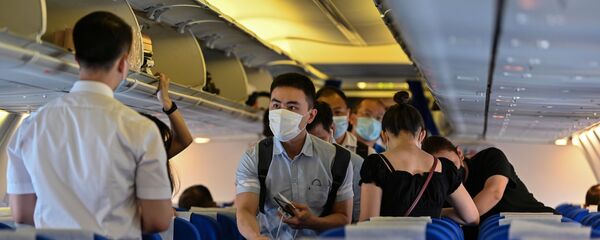 Пассажиры в защитных масках в салоне самолета, архивное фото - Sputnik Казахстан