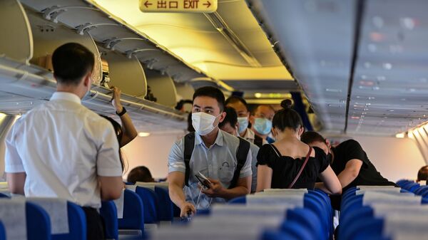 Пассажиры в защитных масках в салоне самолета, архивное фото - Sputnik Казахстан
