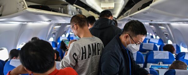 Пассажиры в защитных масках в салоне самолета, архивное фото Пассажиры в защитных масках в салоне самолета, архивное фото - Sputnik Казахстан