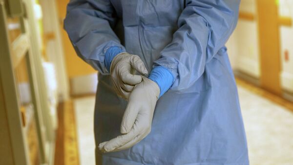 Врач поправляет перчатки в коридоре больницы с коронавирусом перед началом смены  - Sputnik Казахстан