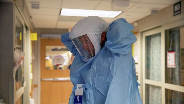 Медик надевает защитный костюм в больнице с коронавирусом  - Sputnik Казахстан