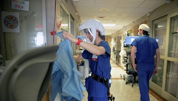 Врач надевает защитный костюм в коридоре больницы с коронавирусом  - Sputnik Казахстан