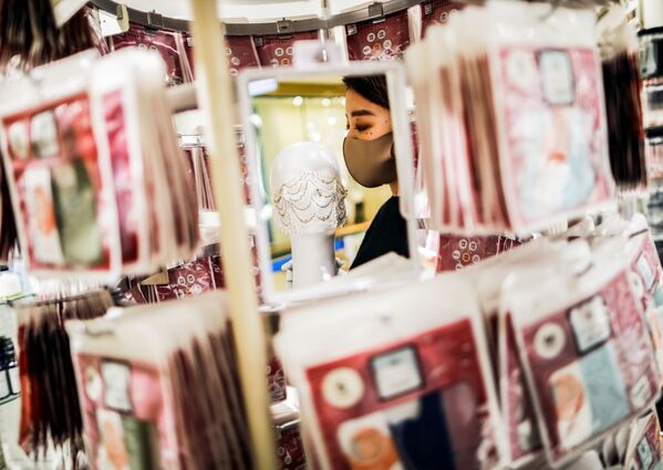 Сотрудник магазина держит маску с драгоценными камнями  в Токио  - Sputnik Қазақстан