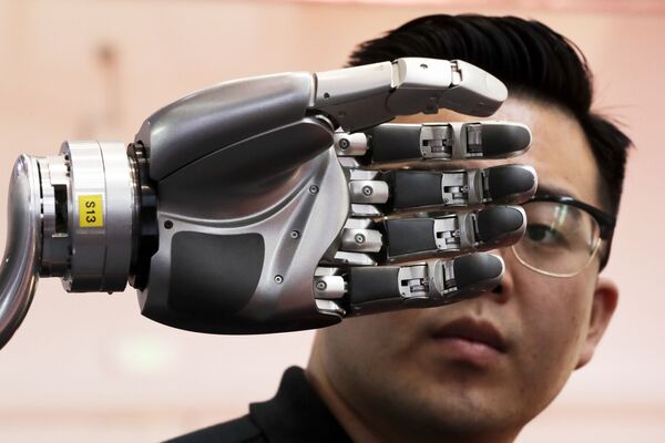 Посетитель разглядывает роботизированную руку, приводимую в движение перчаткой Kinfinity Glove, в Международном выставочном центре в Пекине, Китай, 2017 год - Sputnik Казахстан