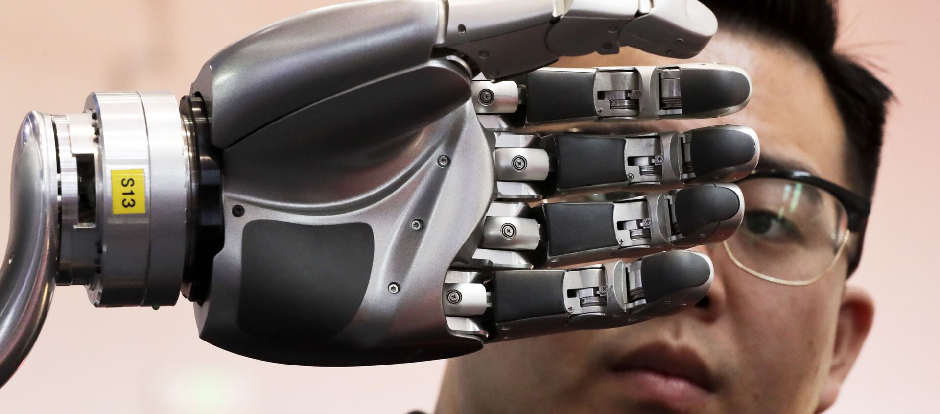 Посетитель разглядывает роботизированную руку, приводимую в движение перчаткой Kinfinity Glove, в Международном выставочном центре в Пекине, Китай, 2017 год - Sputnik Казахстан, 1920, 14.03.2021