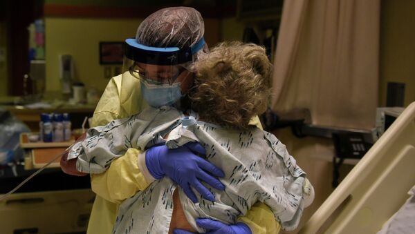 Медсестра поднимает пациента в палате интенсивной терапии в больнице с коронавирусом - Sputnik Казахстан