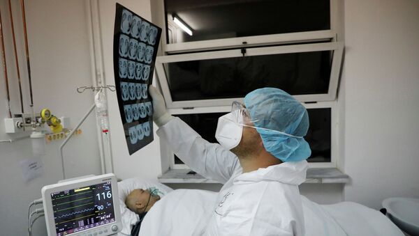 Врач изучает результаты компьютерной томографии пациента из реанимации в больнице с коронавирусом  - Sputnik Казахстан