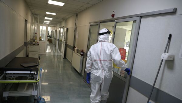 Сотрудник больницы в защитном костюме входит в палату интенсивной терапии в больнице с коронавирусом - Sputnik Қазақстан
