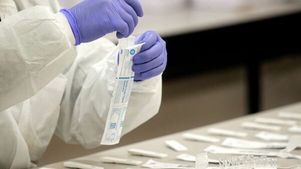 Медик вскрывает пакет с набором для проведения ПЦР-теста на коронавирус - Sputnik Казахстан