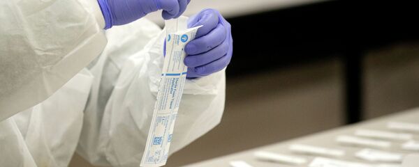 Медик вскрывает пакет с набором для проведения ПЦР-теста на коронавирус Медик вскрывает пакет с набором для проведения ПЦР-теста на коронавирус - Sputnik Казахстан