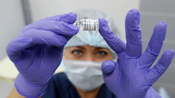 Медсестра держит в руках пузырек с вакциной Спутник V - Sputnik Казахстан