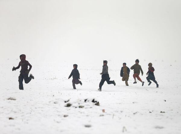 Афганские мальчики играют во время снегопада в Кабуле - Sputnik Казахстан