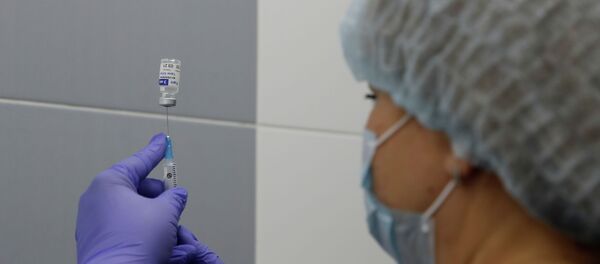 Медик набирает в шприц вакцину от коронавируса Медик набирает в шприц вакцину от коронавируса - Sputnik Казахстан