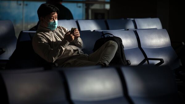 Человек в защитной маске в зоне ожидания аэропорта  - Sputnik Қазақстан