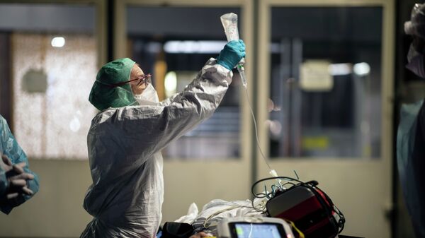 Медработник держит капельницу пациента, прибывшего в больницу с коронавирусом на скорой  - Sputnik Казахстан