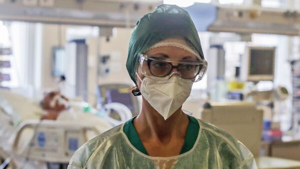 Врач в защитном костюме на обходе в палате интенсивной терапии в больнице с коронавирусом - Sputnik Казахстан