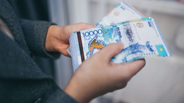 Человек считает бумажные деньги  - Sputnik Казахстан
