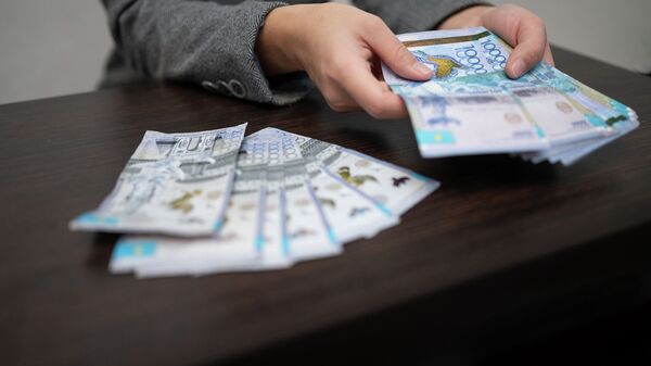 Человек считает бумажные деньги  - Sputnik Казахстан